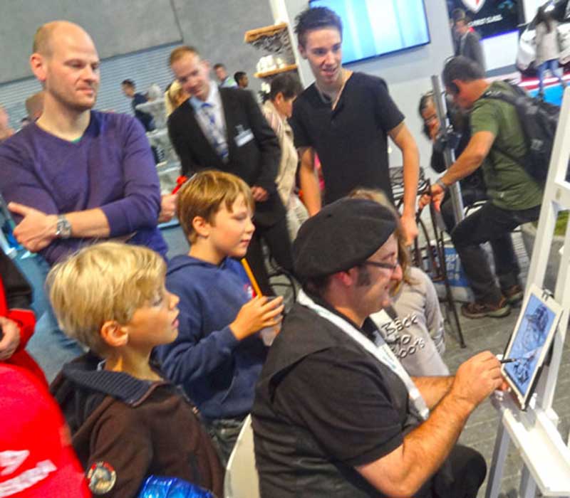 Erol mit iPad-Karikatur als Publikumsmagnet auf einer Messe in Frankfurt am Main