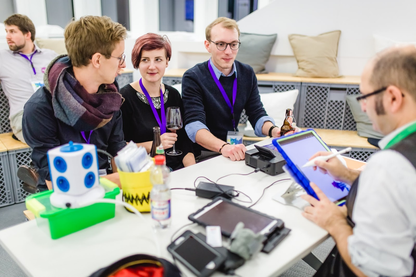 Eine selbstbewusste junge Frau lässt sich von Erol klassisch auf Papier zeichnen; die fertige Karikatur ist im Blickwinkel sichtbar.