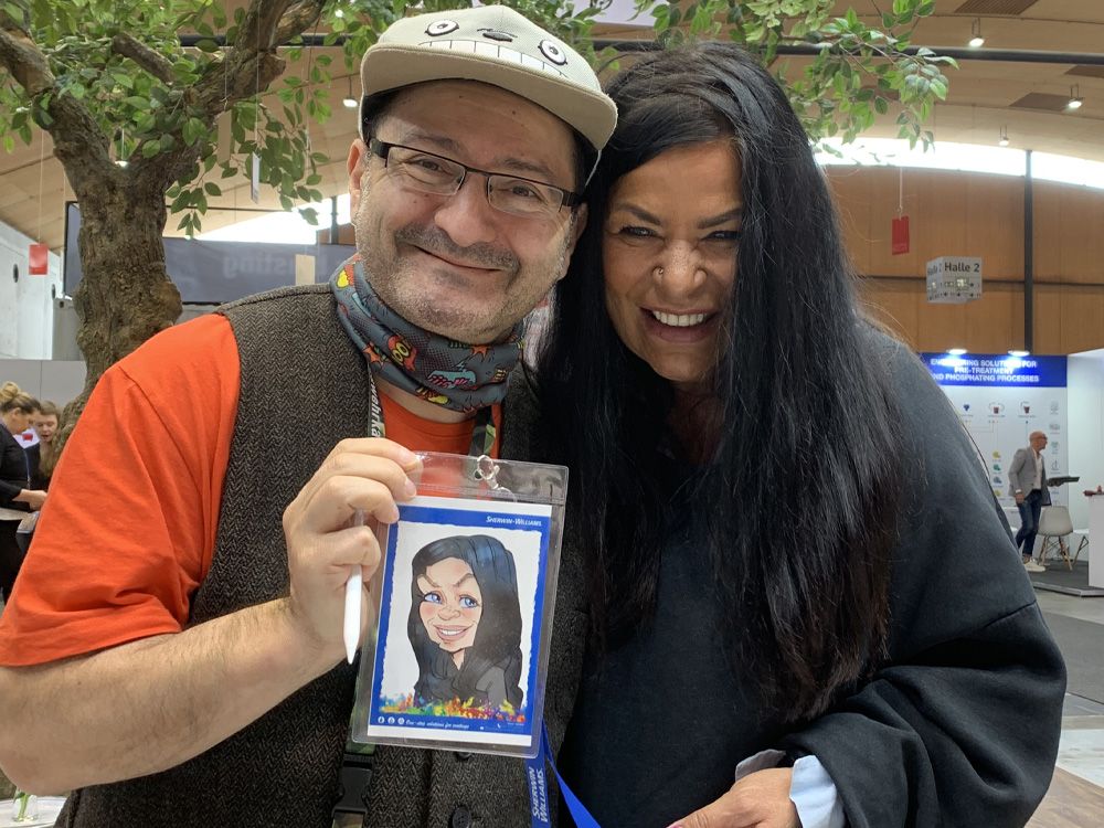 Erol zeichnet eine klassische Karikatur des Brautpaares an der Staffelei.