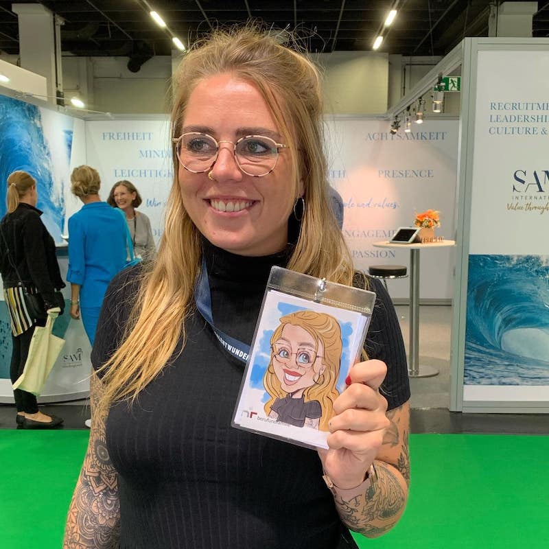 Brautpaar und Hochzeitsgäste schauen Erol beim Live-Zeichnen einer iPad-Karikatur über die Schulter – ein emotionaler Moment auf einer Hochzeitsfeier.